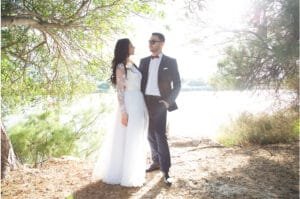 תמונה מצילומי נוף של חתן וכלה על שפת נחל. החתן והכלה מביטים אחד על השניה.